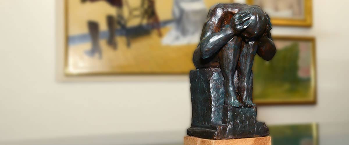 Bronzen beeld van een zittende figuur